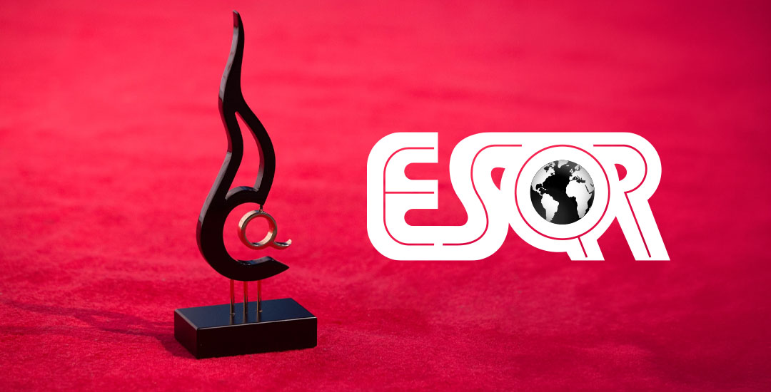 Trofeo ESQR. Una figura de color negro representando una llama, con una letra Q dorada en su centro. La estatuilla está sobre una superficie suave de color rojo.